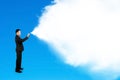 Business man spraying white cloud paint isolated on blue