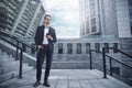 Business man stand at street holding a smartphone in office park Royalty Free Stock Photo