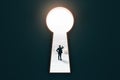 Business man standing in bright keyhole opening with city view on wall background. Future, way and ambition concept Royalty Free Stock Photo