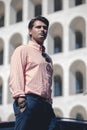 Business man standing in front of a building. Wearing a shirt and formal suit. Hands in the pocket Royalty Free Stock Photo