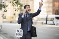 Business man standing hailing a taxi cab in the city Royalty Free Stock Photo