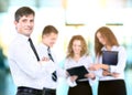 Business man standing with his staff in background at office Royalty Free Stock Photo