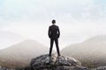 Business man standing on the top of the mountain looking at the Royalty Free Stock Photo