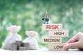 Business man standing on wooden block and money bag on natural green background, Business investment and Risk management concept. Royalty Free Stock Photo