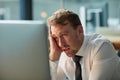 Business man, stress and confused on computer for mistake, error or overwhelmed in his office at night. Tired worker or Royalty Free Stock Photo