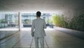 Business man strolling office corridor back view. Relaxed boss going to break