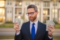 Business man in suit with cash money dollars banknotes outdoor. Hundred dollar bill, financial concept. Real estate Royalty Free Stock Photo