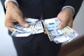 Business man in a suit counting 100 soles bills, peruvian currency concept