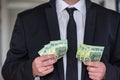 Business man in suit holding euro and dollar banknote for exchange rate. Royalty Free Stock Photo