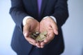 Business man in a suit holding Peruvian coins, Nuevos Soles currency concept