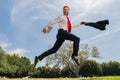 Business man in suit jumping over urban park. Fast business concept. Royalty Free Stock Photo