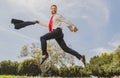 Business man in suit jumping over urban park. Fast business concept. Royalty Free Stock Photo