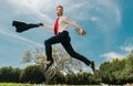 Business man in suit jumping over urban park. Fast business concept. Royalty Free Stock Photo