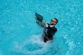 Business man in suit with laptop excited jumping in swimming pool. Summer travel tourism and business concept. Crazy Royalty Free Stock Photo