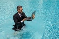 Business man in suit and laptop splash water in swimming pool. Crazy summer business vacation. Funny excited amazed Royalty Free Stock Photo