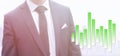 Business man in a suit standing next to a green rising graph Royalty Free Stock Photo