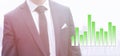 Business man in a suit standing next to a green rising graph Royalty Free Stock Photo