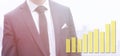 Business man in a suit standing next to a yellow rising graph Royalty Free Stock Photo