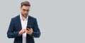 Business man in suit watching on mobile phone. Handsome man using smart phone, type sms message. Social network. Banner