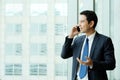 Business man talking smart phone by windows with city view, inside office building background, businessman on phone Royalty Free Stock Photo