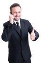 Business man talks on the phone and shows thumb up Royalty Free Stock Photo
