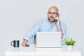 Business man teleworking from home with a laptop and talking on a cell phone. Bald man with glasses