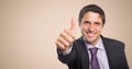 Business man thumbs up against cream background Royalty Free Stock Photo