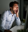 Business man, tired and yawn at desk with computer for programming, coding at night and burnout in IT. Working late Royalty Free Stock Photo