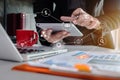 Business man using digital tablet analyzes business data, busy working on laptop computer and business report on office desk. Royalty Free Stock Photo