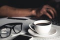 A man types on a laptop, business concept, glasses, a cup of coffee and a pen on a gray background. Royalty Free Stock Photo