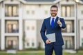 Business man using laptop on home house background. Male business man with computer laptop outside. Business man hold