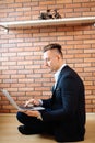 Business man using laptop at home while sitting on floor Royalty Free Stock Photo
