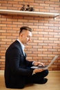 Business man using laptop at home while sitting on floor Royalty Free Stock Photo