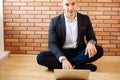 Business man using laptop at home while sitting on floor Royalty Free Stock Photo