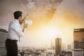 Business man using megaphone talking to the city Royalty Free Stock Photo