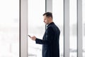 Business man using mobile phone app in airport. Young business professional man texting smartphone walking inside office Royalty Free Stock Photo