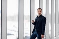 Business man using mobile phone app in airport. Young business professional man texting smartphone walking inside office Royalty Free Stock Photo