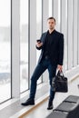 Business man using mobile phone app in airport. Young business professional man texting smartphone walking inside office Royalty Free Stock Photo