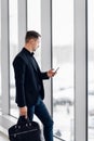 Business man using mobile phone app in airport. Young business professional man texting smartphone walking inside office Royalty Free Stock Photo