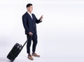 Business man using mobile phone and holding baggage for traveling