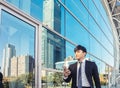 Business man using mobile phone and standing in front of  office building Royalty Free Stock Photo