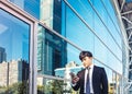 Business man using mobile phone and standing in front of  office building Royalty Free Stock Photo