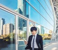 Business man using mobile phone and standing in front of  office building Royalty Free Stock Photo