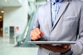 Business Man using Tablet PC in Office building escalator