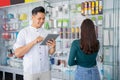 business man using a tablet and a woman looking at and selecting accessory products Royalty Free Stock Photo