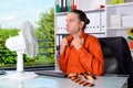 Business man with ventilator at his desk in summerly hot office Royalty Free Stock Photo