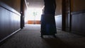 Business man walking at hotel corridor. Businessman with luggage arriving at hotel. Tourist man settling in business Royalty Free Stock Photo