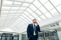 Business man walking while talking on mobile phone on his way to work Royalty Free Stock Photo