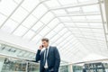 Business man walking while talking on mobile phone on his way to work Royalty Free Stock Photo