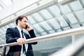 Business man walking while talking on mobile phone on his way to work Royalty Free Stock Photo